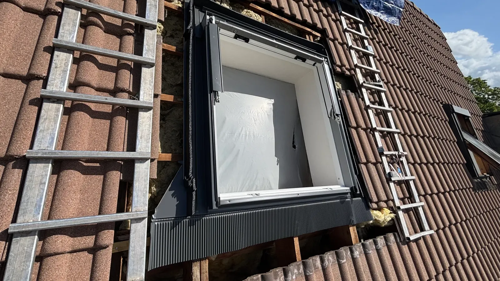 Pose d'une fenêtre de toit Velux sur une toiture en tuiles en Seine-et-Marne